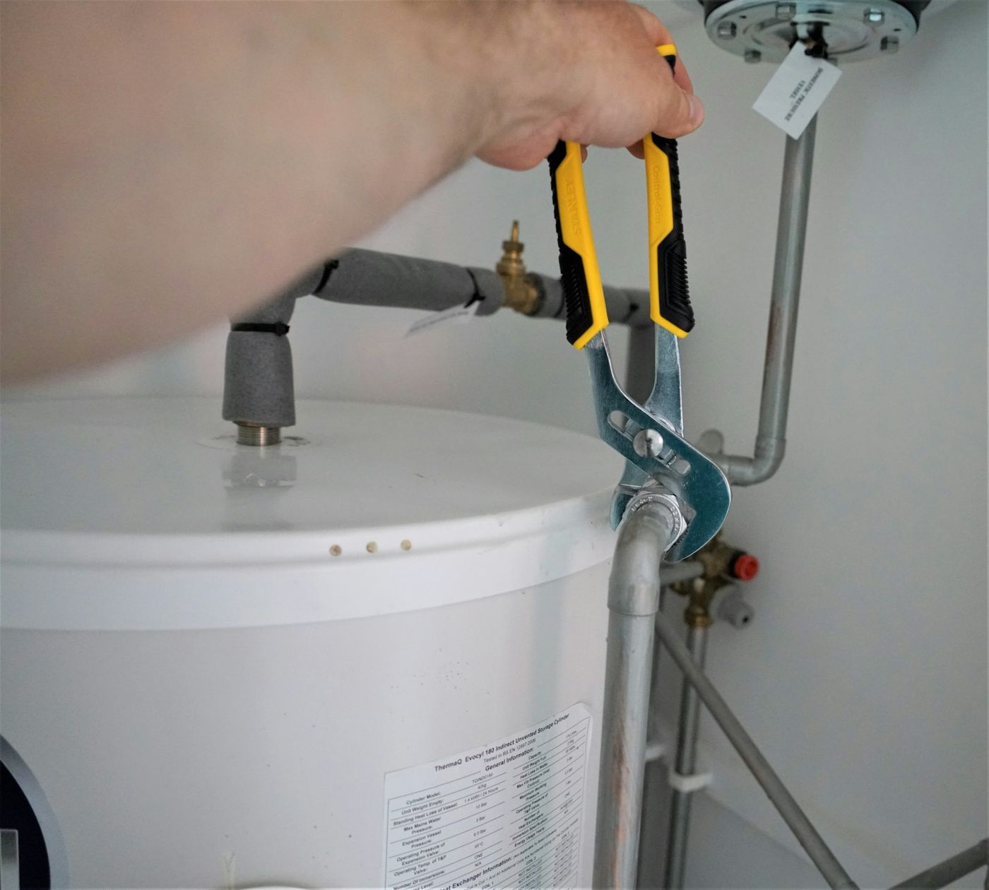 A plumber adjusting the valve on a water heater