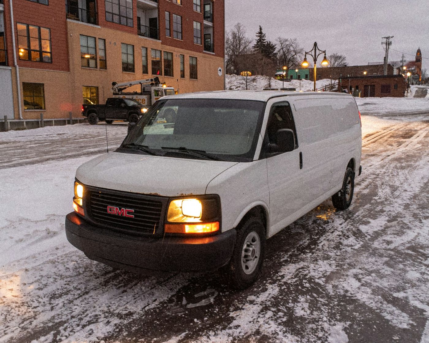 A white Brightline service van parked on a snowy Calgary street